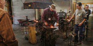 Sparks fly with a hammer at the forge